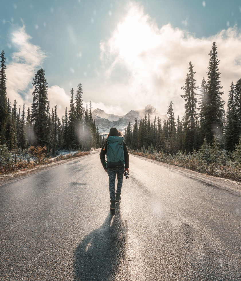 Man backpacker walking with snowing in Banff national park at sunset