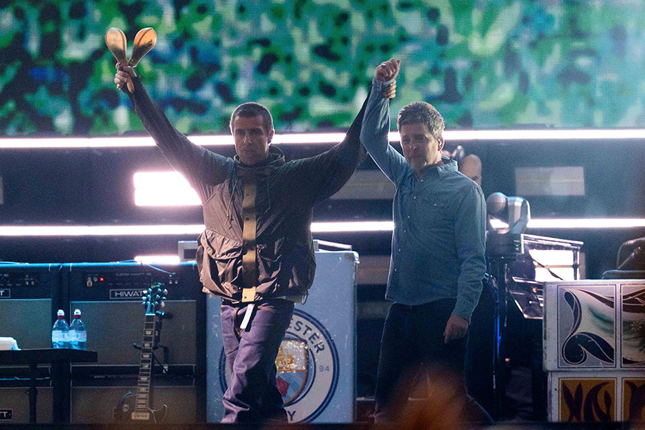 Liam Gallagher holds the hand aloft of Noel Gallagher from the band Oasis as they perform during their reunion concert on Friday, July 4, 2025, in Cardiff.
