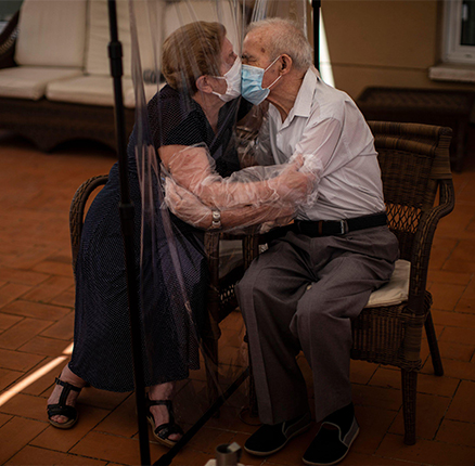 Agustina Cañamero, 81, hugs and kisses her husband Pascual Pérez, 84, through a plastic film screen to avoid contracting the coronavirus at a nursing home in Barcelona, Spain, June 22, 2020.